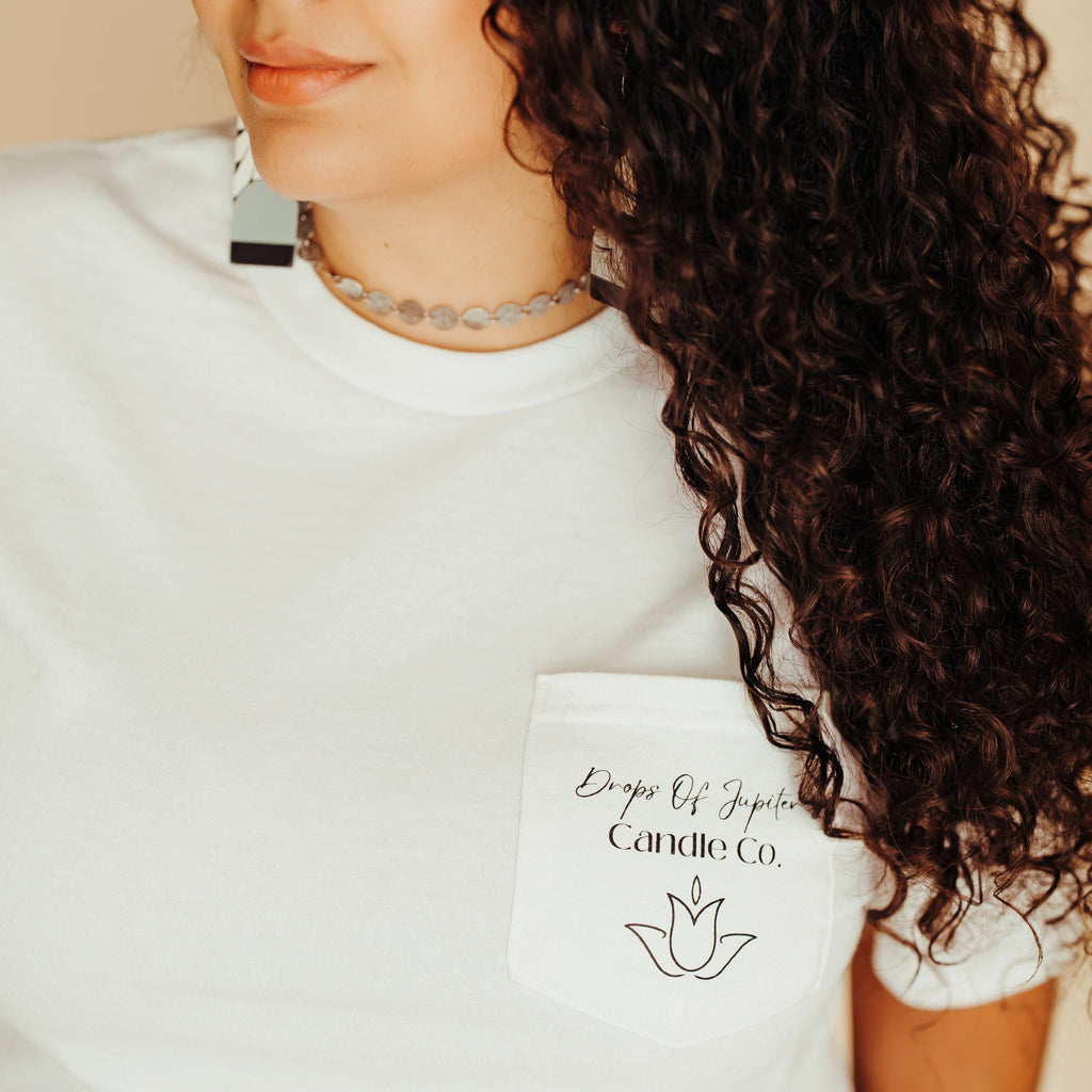 Person wearing a white t-shirt with text and a logo, against a neutral background